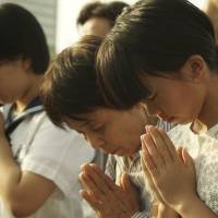 Visitors pray before the cenotaph at Hiroshima Peace Memorial Park in Hiroshima on Thursday. | AP