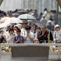 Mourners pray before the cenotaph for the victims of the 1945 atomic bombing, at Peace Memorial Park in Hiroshima on Thursday. A bell tolled and thousands bowed their heads in prayer at the time the bomb struck.  | REUTERS
