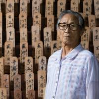 Baek Du-yi poses for a photograph at a shrine inside the Hapchon Welfare Center for Atomic Bomb Survivors in Hapcheon, South Korea, on July 13. | BLOOMBERG
