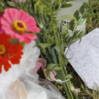 Flowers and a message from a friend are seen near a parking lot in Takatsuki, Osaka, where 13-year-old Natsumi Hirata was found dead last week. | KYODO