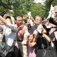 People at Yasukuni Shrine in Tokyo release doves, a symbol of peace, on Saturday morning, the 70th anniversary of the end of World War II. | YOSHIAKI MIURA