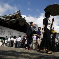 People line up to pray Saturday morning at Yasukuni Shrine on the anniversary of Japan\'s surrender in World War II. Prime Minister Shinzo Abe sent an offering to a shrine for war dead, but had not made a personal visit to the shrine, seen in China and South Korea as a symbol of Tokyo\'s wartime militarism.  | REUTERS