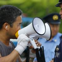 A protester uses a pair of megaphones to make his point during an anti-nuclear demonstration in Tokyo on Tuesday. | AP