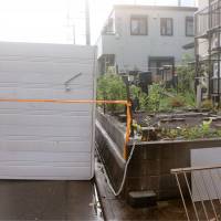 A storage container lies on its side Monday in Fujisawa, Kanagawa Prefecture, after it was apparently blown over by a strong wind gust from a suspected twister. | KYODO