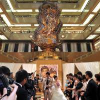 Sponsored by Brideal, The Summer Magokoro Wedding took place in front of a Magokoro (goddess of sincerity) statue, which symbolizes the basic philosophy of Mitsukoshi. The couple chosen for the event, Kazuya Fukushima & Rie (Oka), were married in front of about 50 friends and relatives and about 450 members of the public at Mitsukoshi’s Nihombashi Flagship Store, on Aug. 8. | YOSHIAKI MIURA