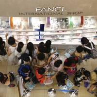 Big spenders: Chinese tourists shop at a cosmetics store in Tokyo\'s Ginza shopping district in June. | AP