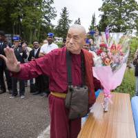 Japan-born monk Surai Sasai leads a prayer ceremony at the headquarters of the Shingon Buddhist sect on Mount Koya, Wakayama Prefecture, on June 14. The portraits depict Buddha and Dalit social reformer Bhimrao Ramji Ambedkar. | CHRISTINA SJOGREN
