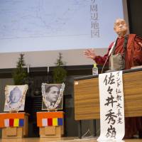 Surai Sasai speaks at the headquarters of the Shingon Buddhist sect on Mount Koya, Wakayama Prefecture, on June 14. The portraits behind him depict the Buddha and Dalit social reformer Bhimrao Ramji Ambedkar. | CHRISTINA SJOGREN