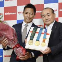 Tadahiro Nomura (left), a three-time Olympic judo champion at 60 kg, attends a Monday news conference in Osaka. | KYODO
