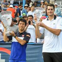 Kei Nishikori holds the Citi Open winner\'s trophy alongside runnerup John Isner after beating the American in Sunday\'s final in Washington. | KYODO