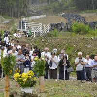 People gathered at a memorial service in Hiroshima\'s Asaminami Ward observe a moment of silence on Thursday for the 75 people who were killed in mudslides that struck the area on Aug. 20 of last year. | KYODO