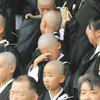 Children from across the country, many with shaved heads, line up for a photo at Kyoto\'s famed Higashi-Honganji Temple on Tuesday. The 136 boys and girls were participating in a rite to enter the Buddhist priesthood called tokudoshiki, which is open to kids age 9 and older and held monthly from February to November. The symbolic event commemorates Shinran, a legendary monk and founder of the Jodo Shinshu sect believed to have entered the priesthood when he was 9 years old. | KYODO