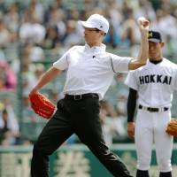 The legendary Sadaharu Oh throws out the first pitch for the National High School Baseball Championship opening game Thursday at Koshien Stadium in Nishinomiya, Hyogo Prefecture. The tournament began 100 years ago. | KYODO