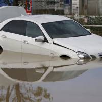 A car is partially submerged in a residential area near Kinugawa River after Typhoon Etau pounded Ibaraki Prefecture with heavy rains this week.  | REUTERS