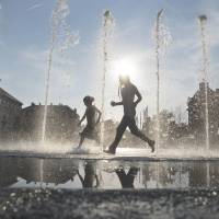Children cool down in a fountain in Vienna on Aug. 11 during a heat wave in which temperatures reached 38 degrees Celsius (100 degrees Fahrenheit). | AFP-JIJI