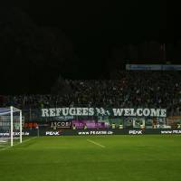 Fans of Werder Bremen hold a banner reading \'Refugees Welcome\' during their German first division Bundesliga soccer match in Darmstadt on Tuesday. | KAI PFAFFENBACH / REUTERS