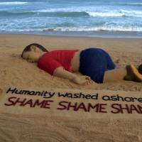 An artist works on a sand sculpture depicting drowned Syrian boy Aylan Kurdi at Puri beach, some 65 km from Bhubaneswar, India, on Friday. | AFP-JIJI