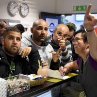 Iraqi refugees buy train tickets to Turku from a public transport center in Tornio, Finland, on Friday. | REUTERS