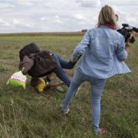 A combination picture shows a migrant carrying a child being tripped by TV camerawoman Petra Laszlo and falling while trying to escape from a collection point in Roszke, Hungary, on Tuesday. | REUTERS