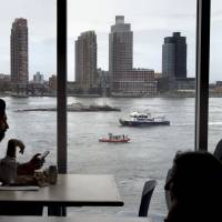 A New York Police Department vessel and United States Coast Guard vessel can be seen patrolling the United Nations headquarters along the East River from inside the U.N. headquarters in Manhattan on Tuesday. | REUTERS