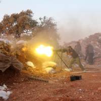 A rebel fighter fires heavy artillery during clashes with government forces and pro-regime militiamen in Syria\'s northwestern Idlib province on Thursday. | AFP-JIJI