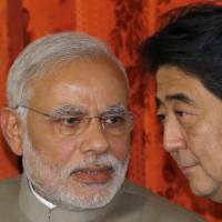 Indian Prime Minister Narendra Modi speaks to Prime Minister Shinzo Abe after their meeting in Tokyo in September 2014. Abe received a birthday message from Modi on Twitter on Monday but sent a reply to the wrong person. | BLOOMBERG