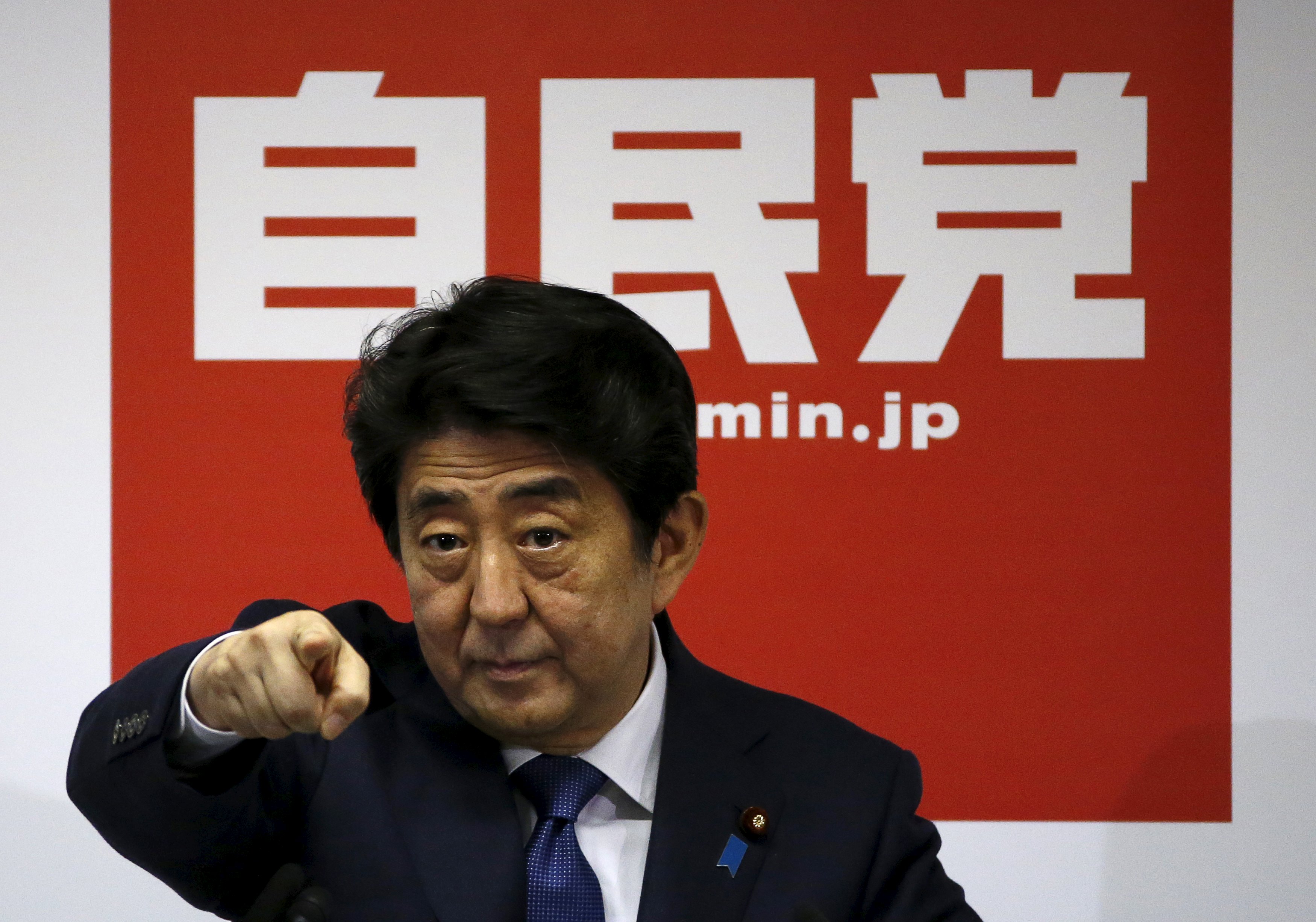 Prime Minister Shinzo Abe points to a reporter during a news conference after he was re-elected as the party leader at the party headquarters Wednesday.  | REUTERS