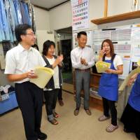Single mom Akemi Hirayama sheds tears of joy at an appreciation ceremony on Sept. 17 at her workplace in Matsubushi, Saitama Prefecture, where she poses surrounded by her colleagues including her boss Miyuki Yoshida (second from left) and CEO Shinichi Nakahata (center). | YOSHIAKI MIURA