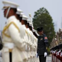 Members of a Self-Defense Force honor guard prepare for a ceremony for U.S. Air Force Lt. Gen. John Dolan at the Defense Ministry in Tokyo in June. | REUTERS