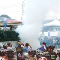 Smoke rises from a drone after it crashed and burst into flames near the starting point of the 5th Maebashi Mt. Akagi Hill Climb bicycle race in Maebashi, Gunma Prefecture, on Sunday morning. | KYODO