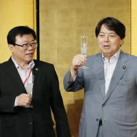 South Korean Agriculture, Food and Rural Affairs Minister Lee Dong Phil (left), Japanese Agriculture, Forestry and Fisheries Minister Yoshimasa Hayashi (center) and Chinese Vice Agriculture Minister Chen Xiaohua make a toast Saturday evening at a Tokyo hotel. The three farm officials were here to discuss cooperation in agriculture. | KYODO