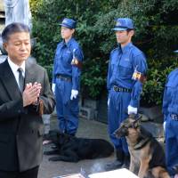 Hiroshi Takada, director at the Metropolitan Police Department crime lab, prays for police dogs during a memorial service held at an animal cemetery in Tokyo\'s Itabashi Ward on Wednesday. | KYODO