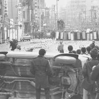 Student protesters set up a barricade across a street in Tokyo’s Kanda district on Jan. 18, 1969, in a face-off with riot police.  | KYODO