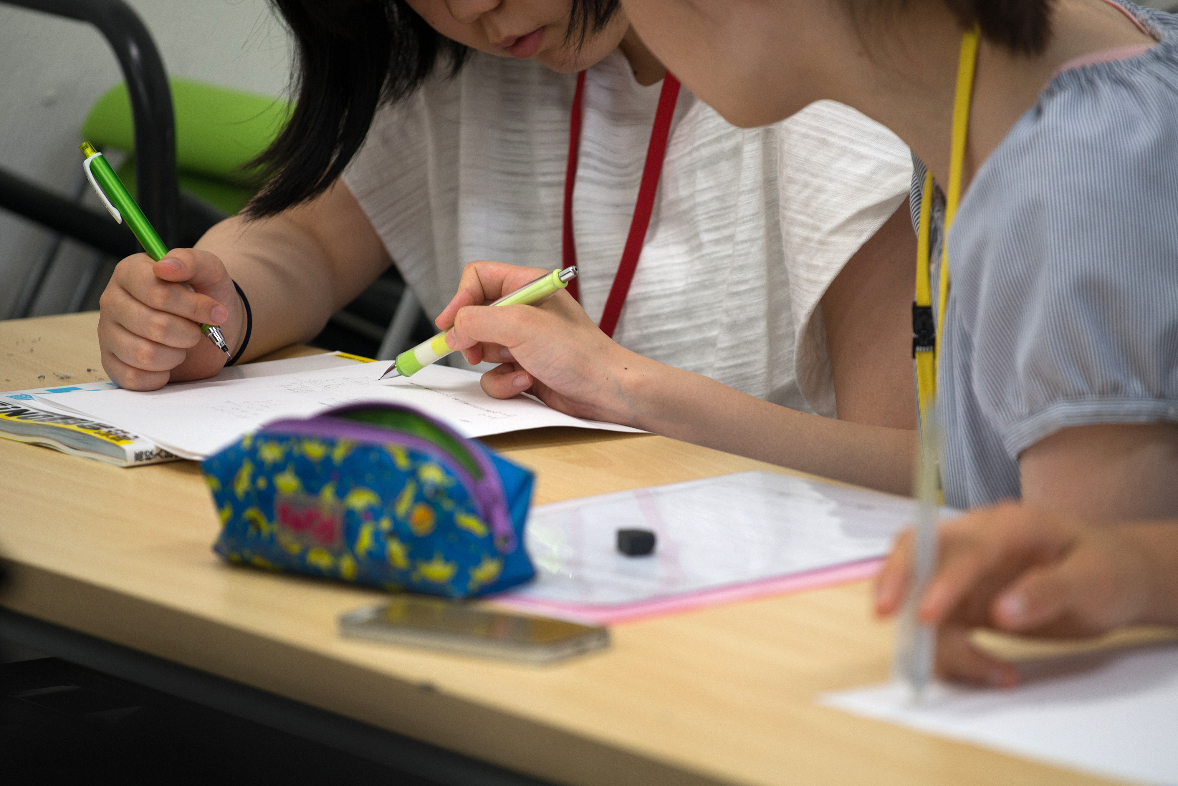 A university student volunteer teaches math to a junior high school student at the Tadazemi free cram school in Tokyo. | BLOOMBERG