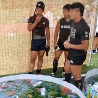 High school rugby players eat vegetables provided by local residents at the Gose rugby festival in Gose, Nara Prefecture, on July 21. | KYODO