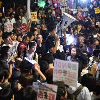 Members of SEALDs (Students Emergency Action for Liberal Democracies) in front of the National Diet in Tokyo stage a rally Friday night against Prime Minister Shinzo Abe\'s controversial security bills. Early Saturday morning the ruling bloc passed security bills that would allow troops to fight on foreign soil for the first time since World War II. | AFP-JIJI