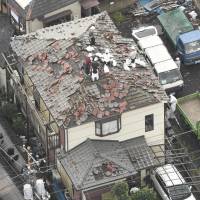 Damaged roof tiles are seen in the city of Chiba Monday following reports that severe winds hit the area the night before, spurring speculation that a tornado struck. | KYODO