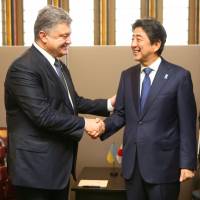 Prime Minister Shinzo Abe and Ukrainian President Petro Poroshenko shake hands after meeting on the sidelines of the U.N. General Assembly in New York on Monday. | POOL / KYODO