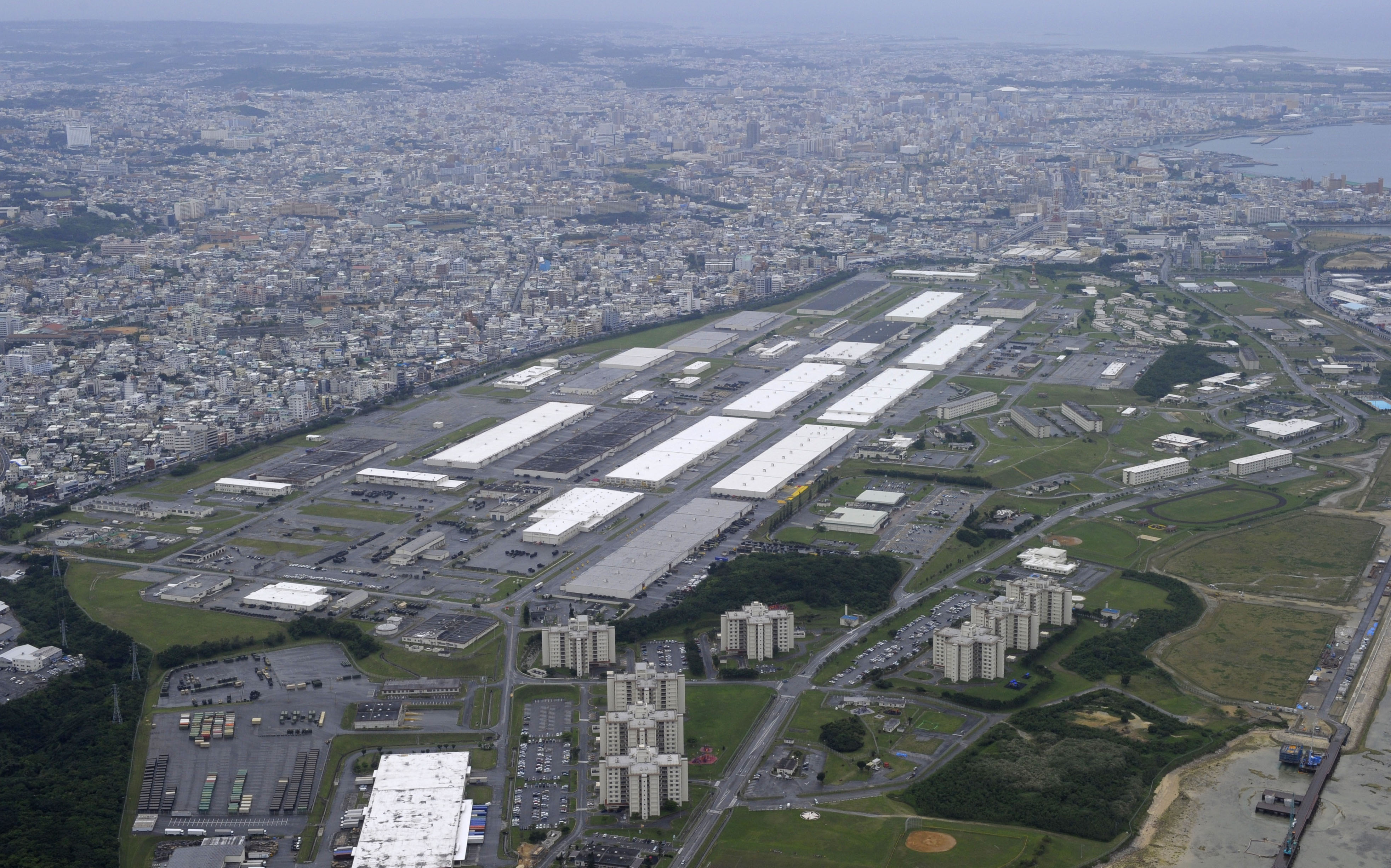 Bad lands: An aerial view from 2012 shows Camp Kinser, a U.S. Marine Corps supply base, with the Okinawan capital, Naha, in the background. The Pentagon is apparently sitting on a report that details 'evidence of environmental contamination' at the site due to 'past hazardous material storage.' | KYODO