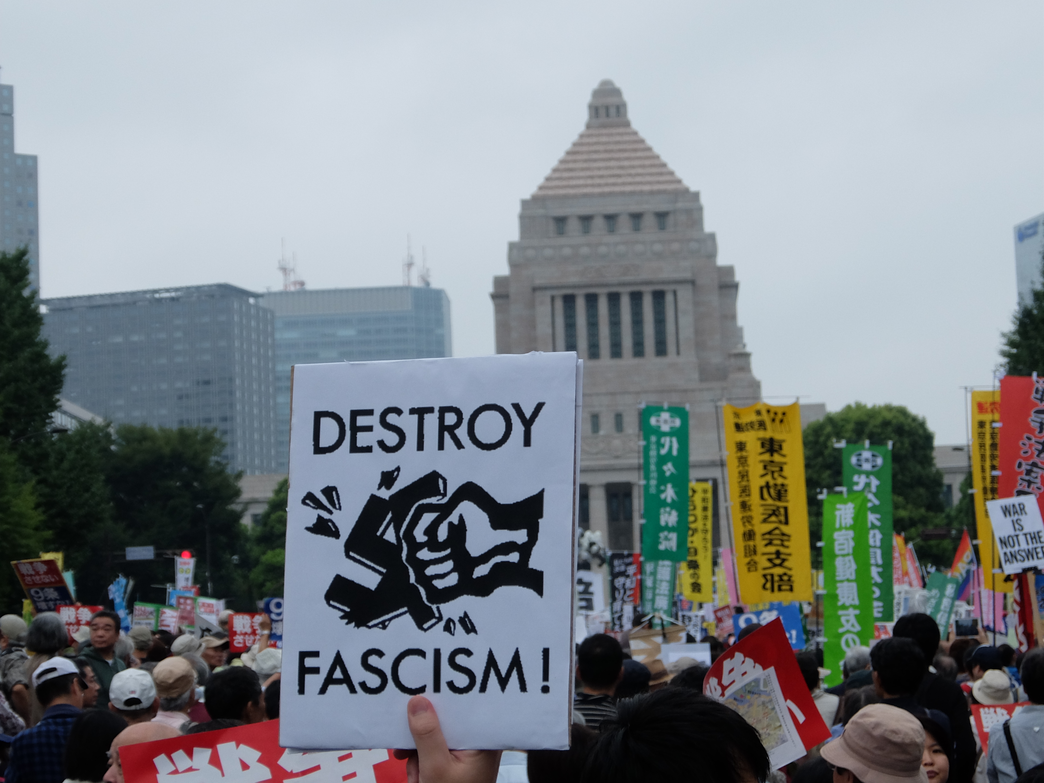 Youth against fascism: A protester holds up a sign during a demonstration in front of the Diet building in Tokyo on Aug. 30. | JEFF KINGSTON