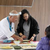 Chef Hidekazu Tojo shows an Inuit woman how to make sushi during our Arctic cruise in July. | YOICHI YABE