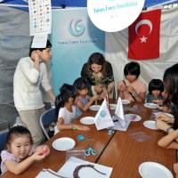 Children make bracelets with Turkish beads at the Turkish embassy booth. | YOSHIAKI MIURA