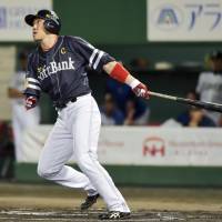 Fukuoka Softbank\'s Seiichi Uchikawa hits a three-run shot in the first inning of the Hawks\' 8-5 win over the Fighters on Tuesday. | KYODO