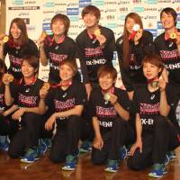Japan\'s women\'s basketball team members hold up their FIBA Asia Women\'s Championship winners\' medals in Narita, Chiba Pref., after returning to Japan on Sunday. | KAZ NAGATSUKA