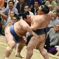 Kotoshogiku (left) outmuscles Kisenosato en route to victory on Tuesday at the Autumn Grand Sumo Tournament. | KYODO