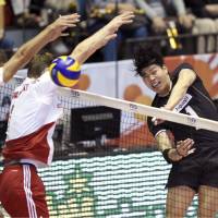 Kunihiro Shimizu spikes the ball past two Poland defenders on Tuesday during the FIVB Men\'s Volleyball World Cup in Tokyo. Unbeaten Poland defeated Japan  24-26, 27-25, 25-21, 25-19. | KYODO