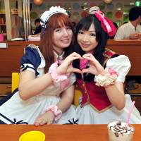 Margarita Jimenez (left) poses with her Japanese host Emi at the @home cafe in Akihabara on Sept. 15. Jimenez won the chance to come to Japan and experience a maid cafe after winning a contest at an anime expo in her home country Chile. | YOSHIAKI MIURA
