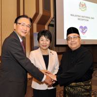 Malaysian Ambassador Ahmad Izlan Idris (right) joins Chairman of the Japan-Malaysia Parliamentary Friendship League and former National Public Safety Commission Chairman Keiji Furuya (left) and  Justice Minister Yoko Kamikawa (center) during a reception to celebrate the country\'s National Day at the Imperial Hotel Tokyo on Sept. 8. | YOSHIAKI MIURA