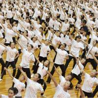 Participants spin their batons in a gymnasium in Osaka on Monday to break the Guinness world record for the most people twirling batons at the same time. A total of 2,002 people took part in the event to break the former record of 1,012 set in the Netherlands in 2004. | KYODO
