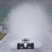 Mercedes driver Lewis Hamilton kicks up a cloud of spray during Friday\'s first Japanese Grand Prix practice session in Suzuka, Mie Prefecture. On a day when rain battered the circuit, 10 riders skipped the first practice session. Hamilton, the 2015 driver standings leader, sat in third place for the second practice session ahead of Sunday\'s Formula One race. | REUTERS